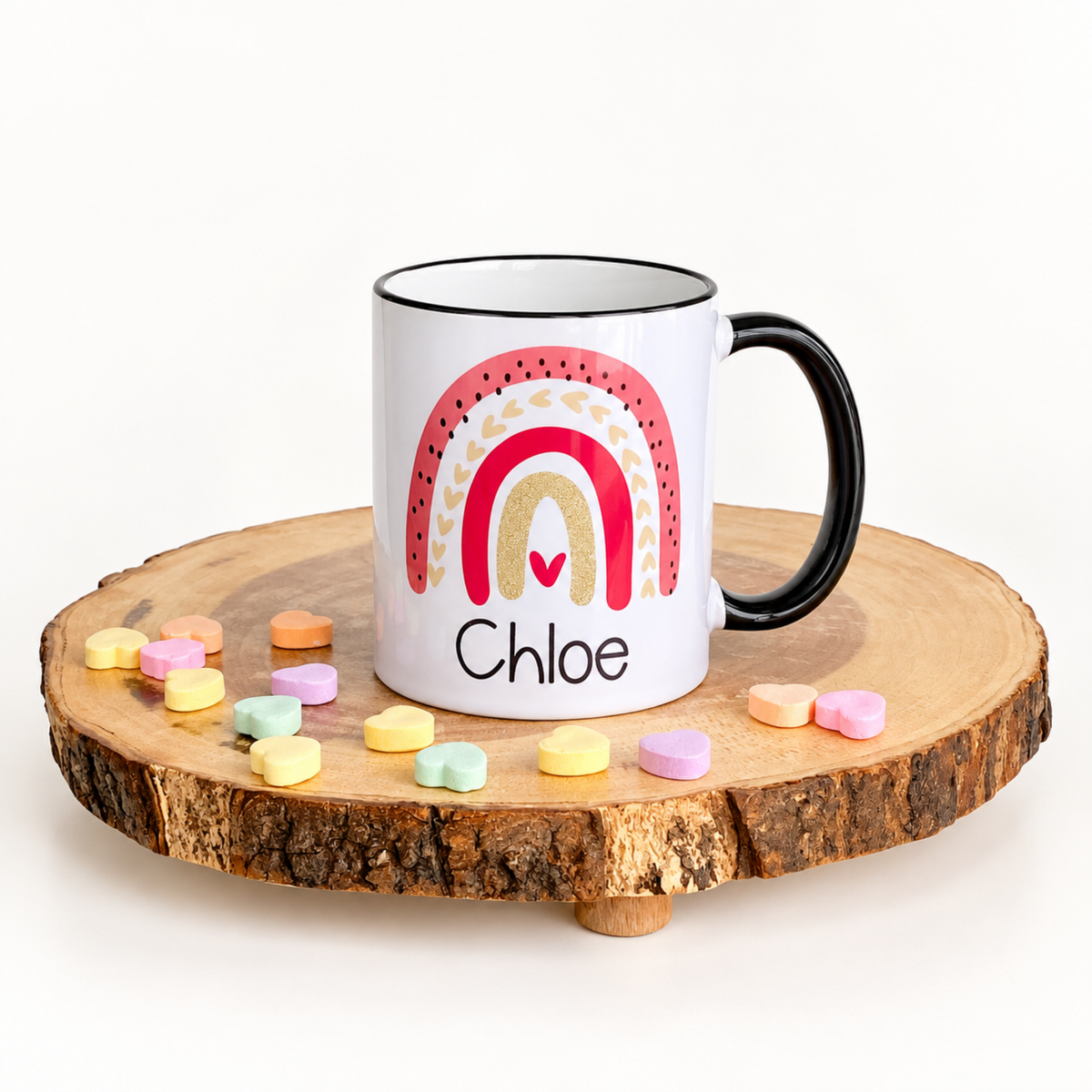 Personalized Rainbow kids’ mug with the name Chloe, black handle, and black rim.